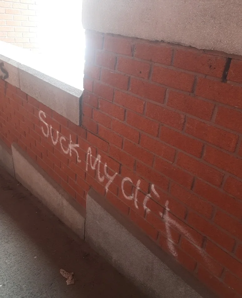 Graffiti sur un muret de briques rouges à Trois-Rivières